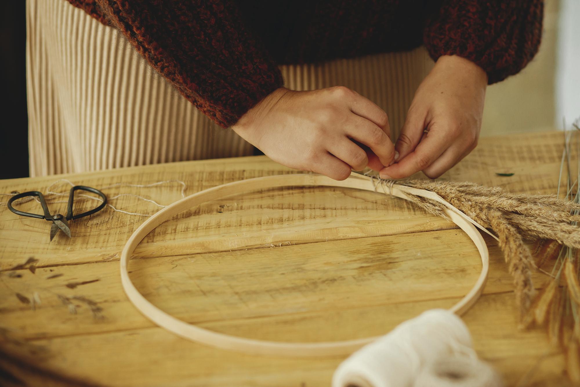 Worker preparing embroidery hoop in studio